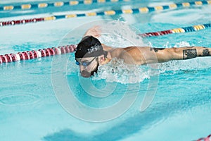 Professional swimmer swims the butterfly in the pool