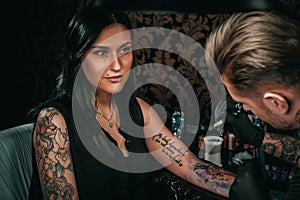 Professional tattoo artist makes a tattoo on a young girl`s hand photo