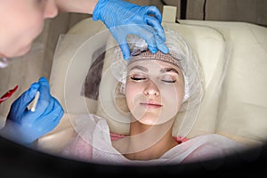 Professional Tattoo Markup with Transparent Facial Ruler On Eyebrows of Young Caucasian Woman During a Process of Permanent make