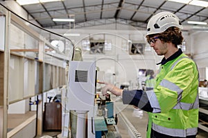 Professional technician engineer male staff worker control operate wood CNC machine