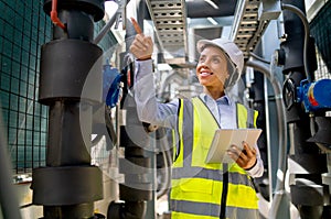 Professional technician worker or engineer woman stay in area of pipe network and point to the left side in area of construction