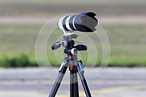 Professional telephoto lens for DSLR camera on the tripod