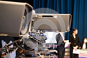 Professional television camera with large lens on a tripod during TV recording
