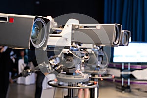 Professional television camera with large lens on a tripod during TV recording