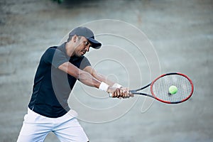 Professional tennis player hitting ball with racket