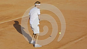 Professional tennis player hitting ball with racket, training on court, sports