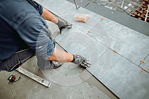 Professional tiler and ceramic tiles worker on construction site