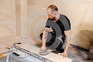 Tiler installing large format tile on bathroom wall using suction cup