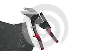Professional tool,slate cutter,black with red handles,isolated on white background,and sheets of exterior natural slate