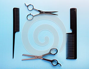 Professional tools for hairdresser on blue background: hair combs and haircutting scissors