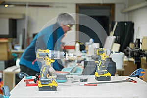Professional tools in a small repair and construction workshop. Owner in blurred