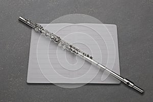 Professional transverse flute  and empty music score rest on a slate board with copy space for your text