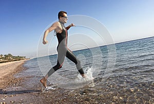 Professional triathlete practicing in open water. Plunge in sea.