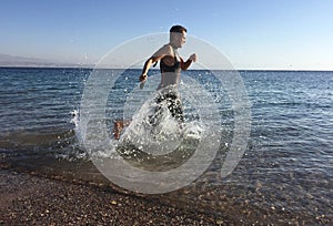 Professional triathlete practicing in open water. Plunge in sea.