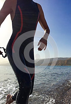 Professional triathlete practicing in open water. Swimming in se