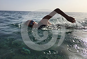 Professional triathlete practicing in open water. Swimming in se photo