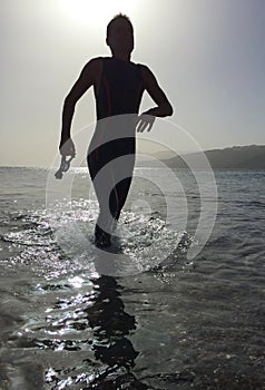 Professional triathlete practicing in open water. Swimming in se photo