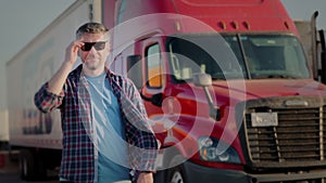 Professional Truck Driver approaches his truck and Behind Him Parked Long Haul Semi-Truck . Close up