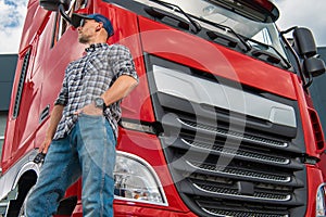 Professional Truck Driver and His Heavy Duty Red Semi Tractor