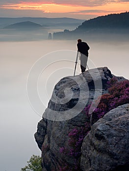 Professional use mirror camera and tripod on peak of rock