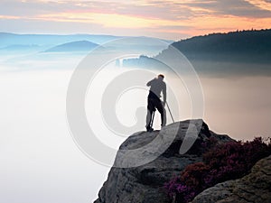 Professional use mirror camera and tripod on peak of rock