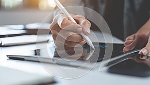 Professional uses a stylus on a tablet for digital design or work.