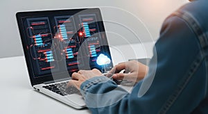 Professional using a laptop to analyze complex data visualizations and coding interfaces