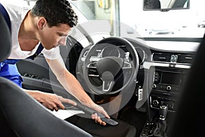 Professional vehicle preparation in a car wash - worker sucks up