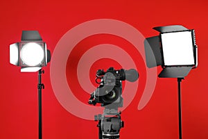 Professional video camera and lighting equipment on red
