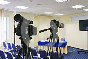 Professional video camera mounted on a tripod to record video during a press conference, an event, a meeting of journalists.