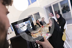 Professional videograph recording video while Muslim family having iftar together during Ramadan