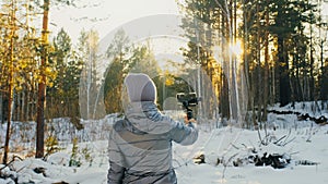 Professional Videographer Holding DSLR Camera on 3-axis Gimbal Stabilization Device in Winter. Cinematographer Operator