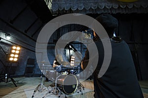 Professional videographer using cinema digital video camera for filming a drummer for a music video.