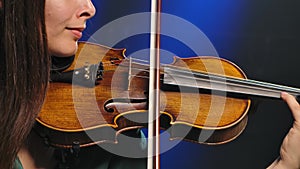 Professional violin playing. Close-up instrument in the hands of a young woman musician. Slow motion.