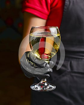 Professional waiter in uniform is serving wine in a glass. Champagne serve for party or celebration in restaurant