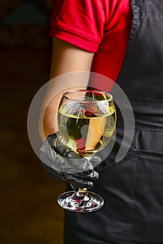 Professional waiter in uniform is serving wine in a glass. Champagne serve for party or celebration in restaurant