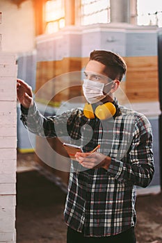 Professional warehouse worker inspecting wood stock inventory