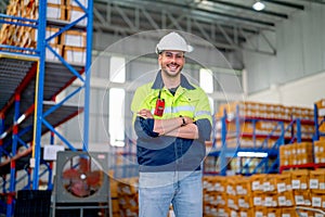 Professional warehouse worker stand with arm-crossed and smiling also look at camera stand in front of shelves with cardbox of
