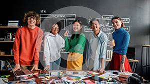 Professional web designers. Portrait of creative designer team looking at camera and smiling while working together in