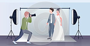 Professional wedding photographer shooting on camera newly weds couple bride and groom embracing posing in modern photo