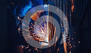 Professional welder performs welding work on metal in protective mask. Industrial worker concept