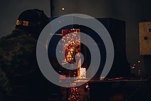 Professional welder performs welding work on metal in protective mask. Industrial worker concept