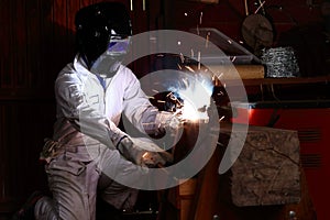 Professional welder in safety uniform welding metal in the factory. Industrial concept.