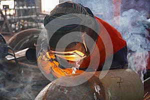 A professional welder welds a pipe with a diameter of DN250 for the process pipeline and fixes the defective sections of the seam