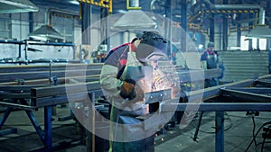 Professional Welder Working at factory facility. Factory workshop with a male technician welding in it