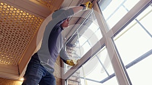 a professional window cleaner soaps and squeegies a window clean, male worker