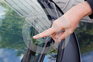 Professional windshield man repairman pointed a crack in car glass