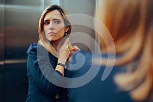 Professional Woman Arranging her Hair in an Elevator Mirror