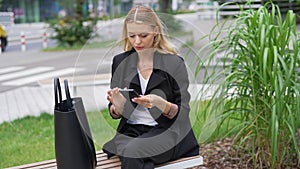 Professional Woman Checking Phone on City Bench