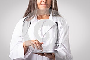 Professional woman doctor physician using digital tablet, reviewing medical record, digital document, cropped, closeup